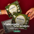 Dos tarjetas de la edición Clásica Mahjong 2026 sostenidas en la mano, con las manos y reglas en español